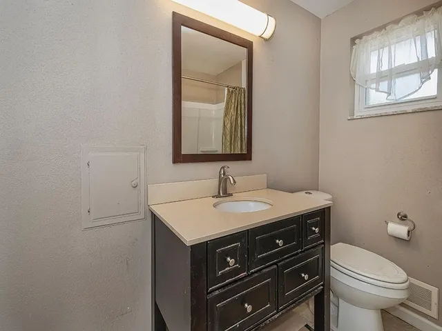 a bathroom with a sink a toilet and mirror