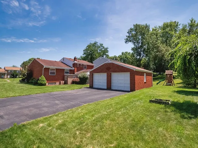 a view of a house with a yard and a garage
