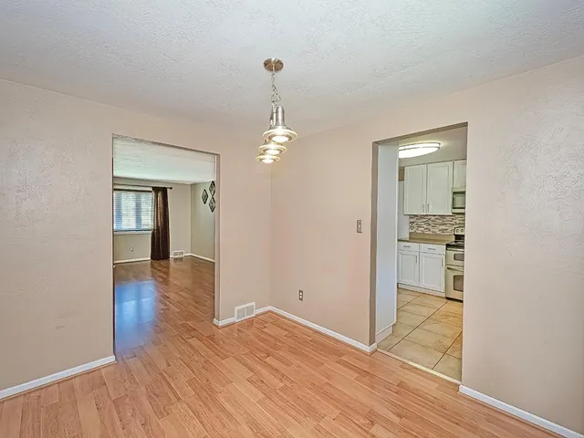 a view of a room with wooden floor staircase and front door
