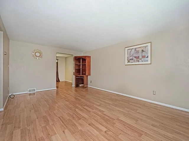 an empty room with wooden floor and closet