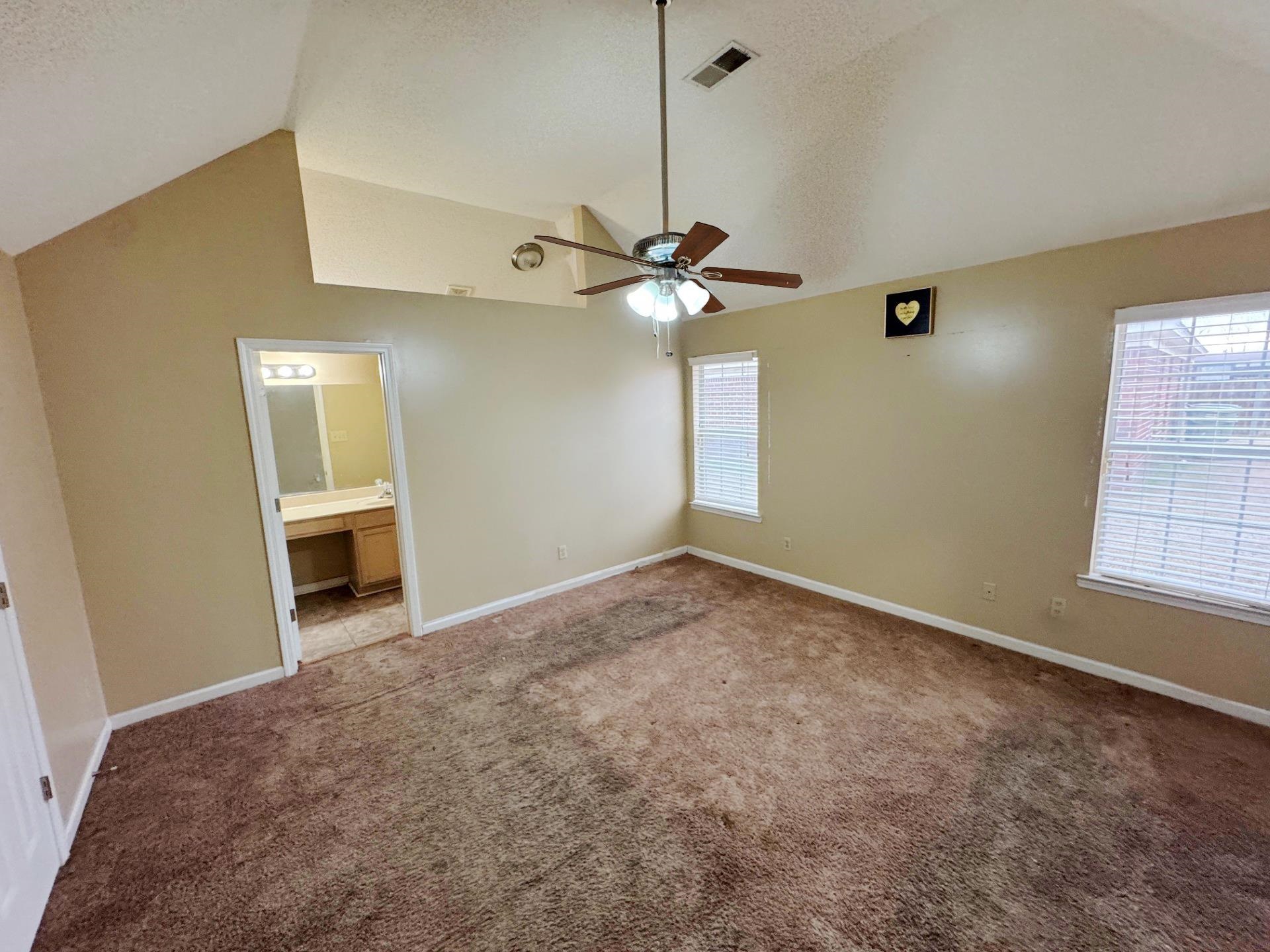 76 Autumn Branch Lane Memphis, TN 38109 - Photo 6 of 13 Unfurnished bedroom with ceiling fan, lofted ceiling, ensuite bathroom, and light carpet