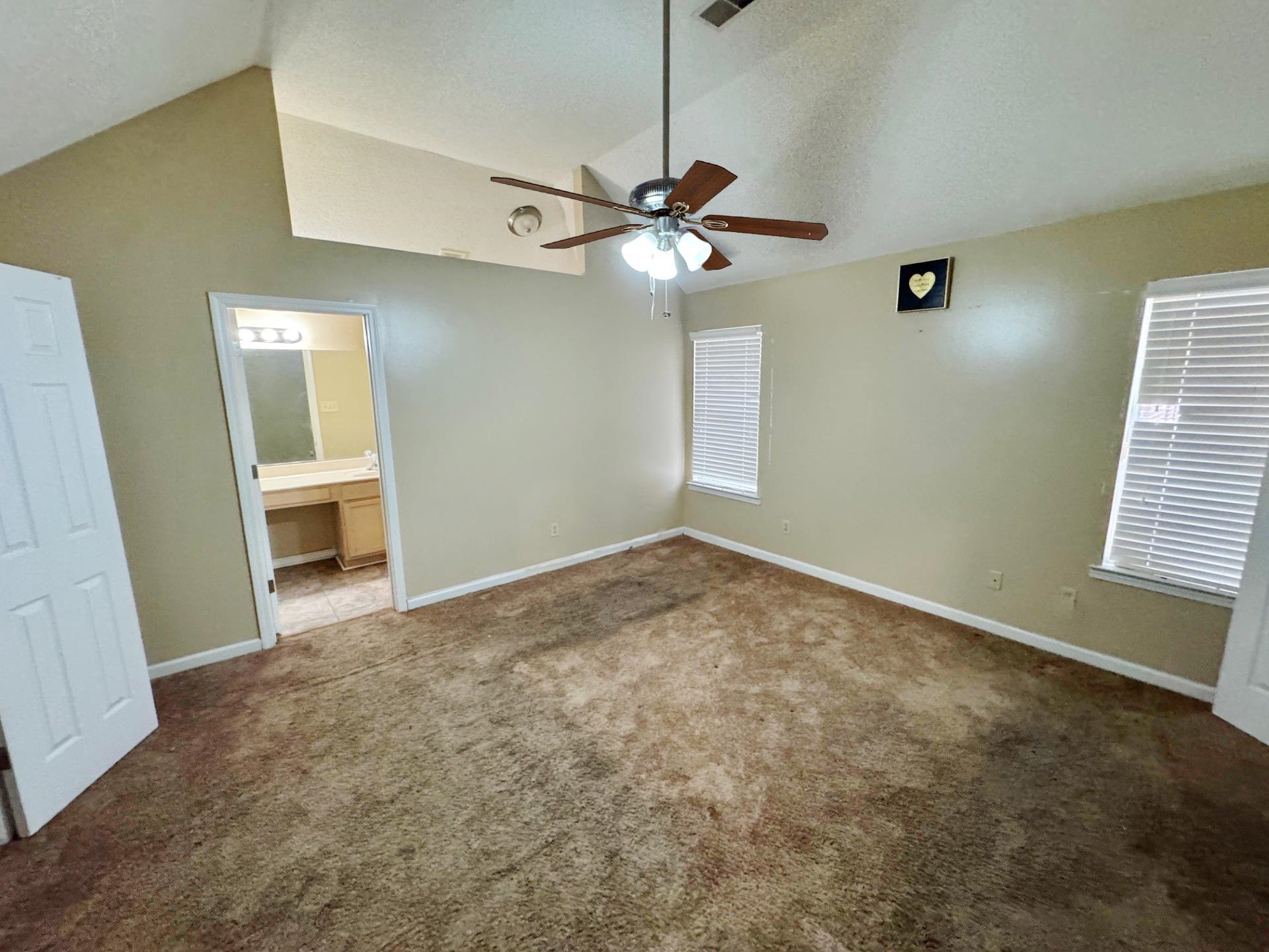 76 Autumn Branch Lane Memphis, TN 38109 - Photo 7 of 13 Unfurnished bedroom featuring lofted ceiling, ensuite bathroom, carpet flooring, ceiling fan, and a textured ceiling