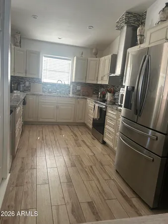 a kitchen with a refrigerator wooden floor and window