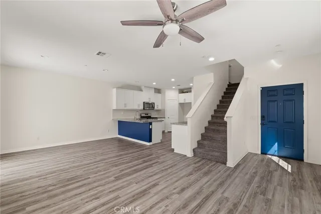 an empty room with wooden floor and staircase