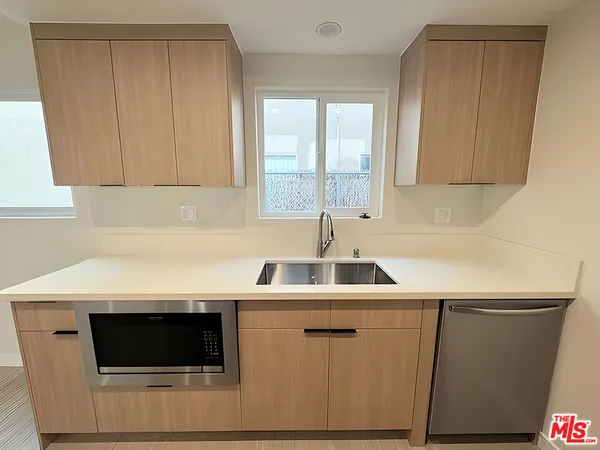 a kitchen with a sink a microwave and cabinets
