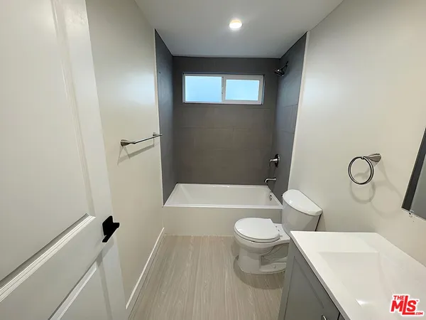 a bathroom with a bathtub sink mirror vanity and toilet