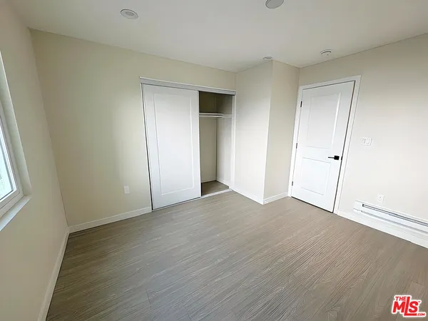 an empty room with wooden floor and closet