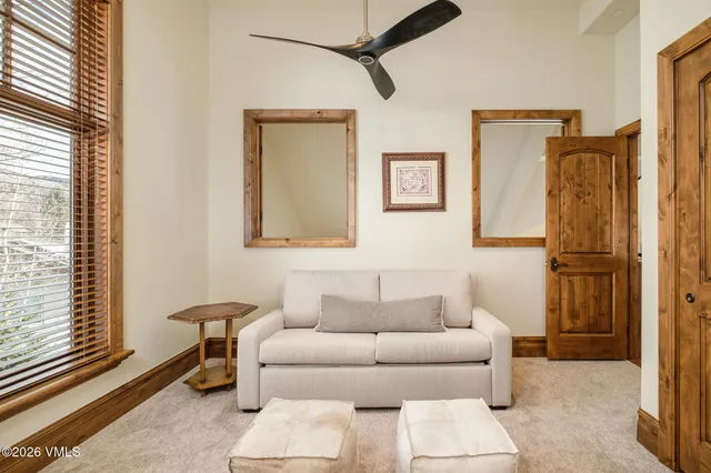a living room with furniture a flat screen tv and large windows