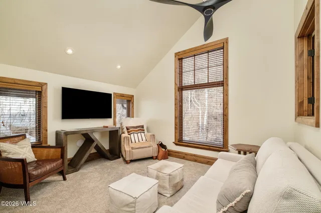 a living room with furniture a flat screen tv and a floor to ceiling window