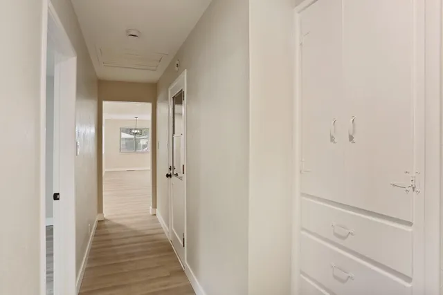 a view of a hallway with wooden floor