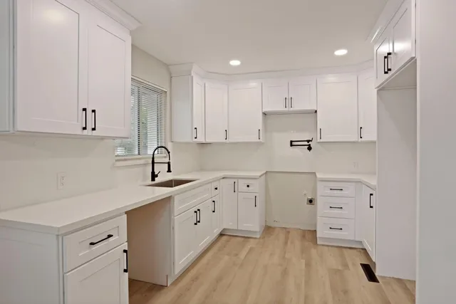 a kitchen with white cabinets white appliances