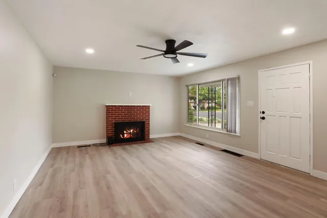 a view of an empty room with a fireplace and a window