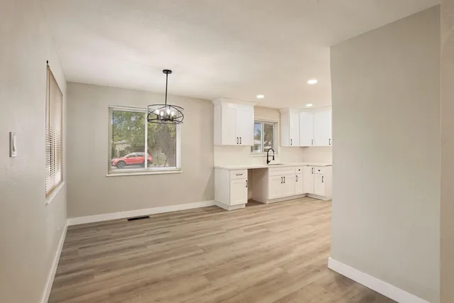 a view of a kitchen with wooden floor and windows