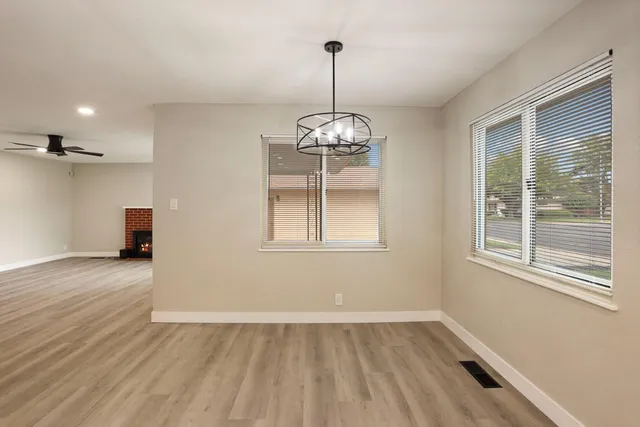 a view of a room with wooden floor exposed radiator and windows