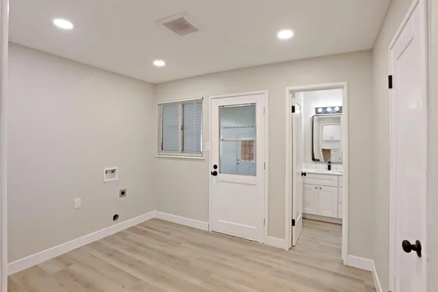 an empty room with wooden floor and mirror