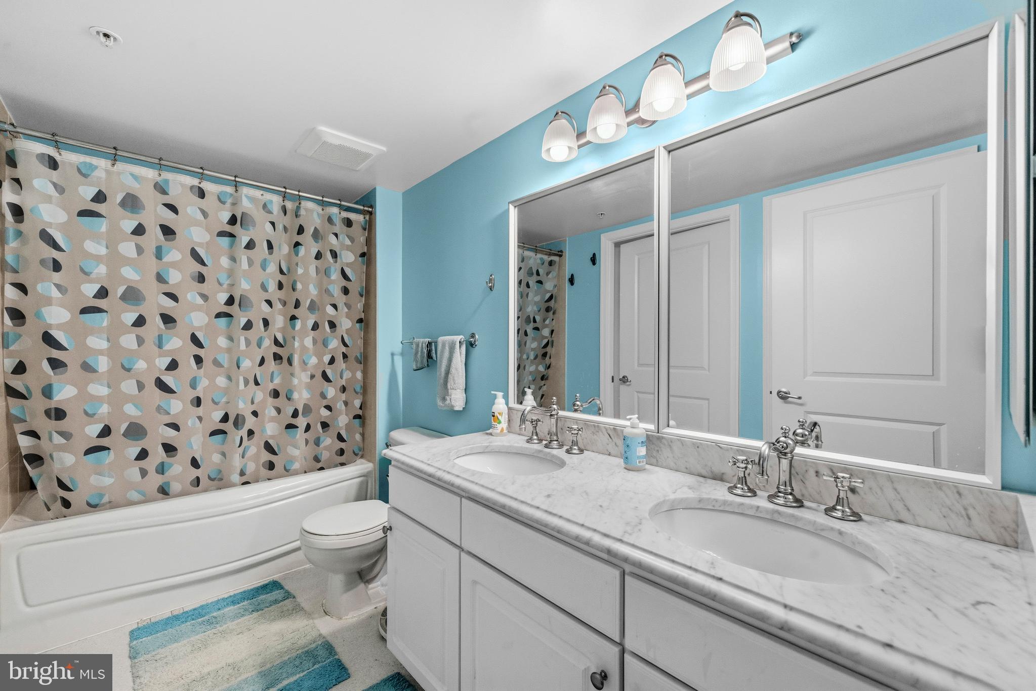 11800 Sunset Hills Road, Unit 726 Reston, VA 20190 - Photo 15 of 36 a bathroom with a granite countertop sink a toilet and a mirror