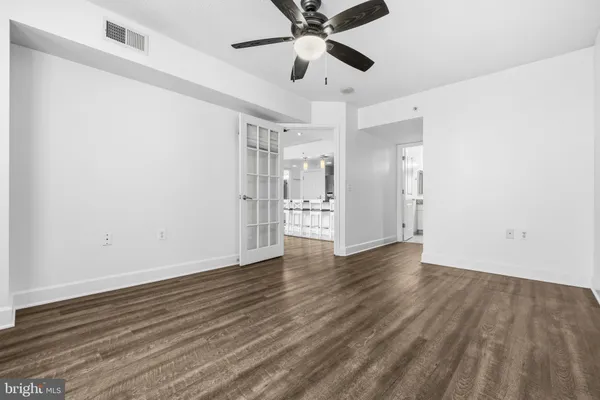 a view of a hallway with wooden floor and a bathroom