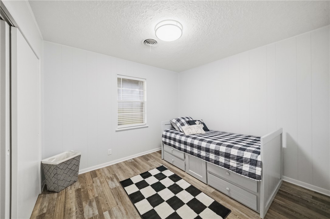 415 West Decherd Street Franklin, TX 77856 - Photo 15 of 28 a bedroom with a bed and wooden floor