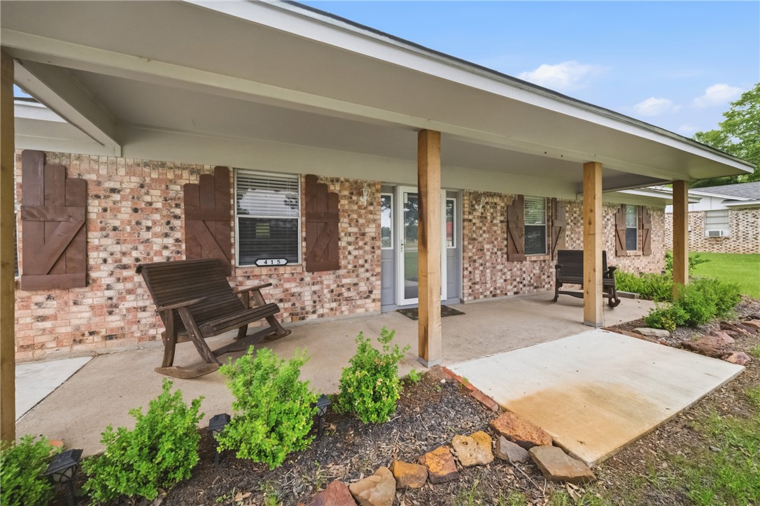 415 West Decherd Street Franklin, TX 77856 - Photo 2 of 28 a view of a patio with table and chairs potted plants and floor to ceiling window