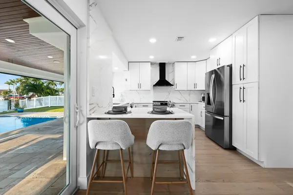 a kitchen with a dining table chairs and large window
