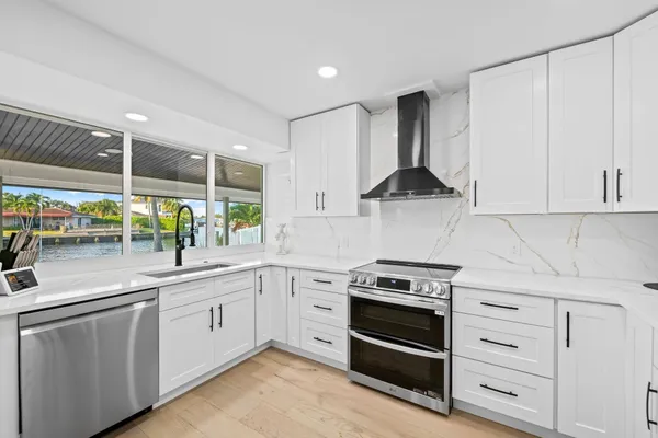 a kitchen with a sink stainless steel appliances and white cabinets