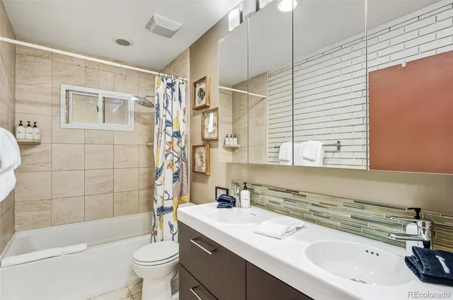 a bathroom with a sink a toilet a mirror a bathtub and shower