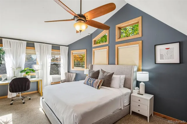 a bedroom with a bed and large windows