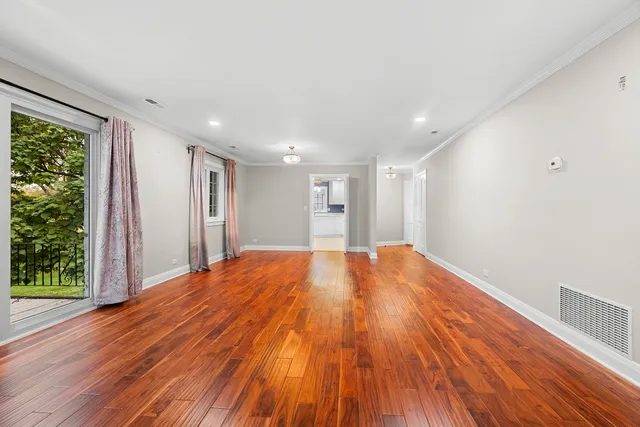 a big room with wooden floor and natural light