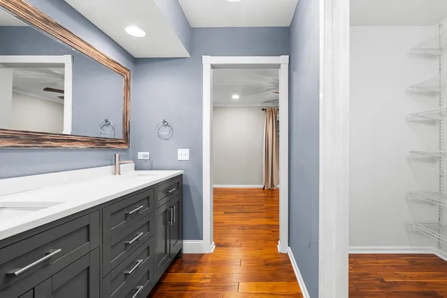 a en suite bathroom with a granite countertop sink and a mirror