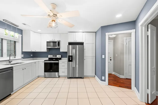 a open kitchen with stainless steel appliances granite countertop a refrigerator and a sink
