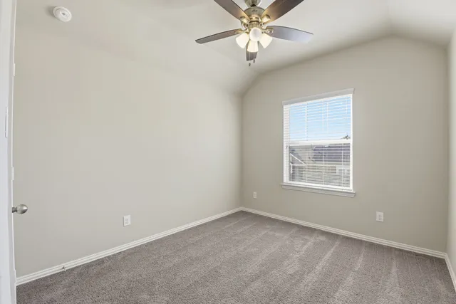 an empty room with a window and a fan