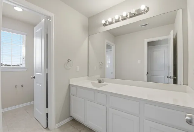 a spacious bathroom with double sink and a mirror