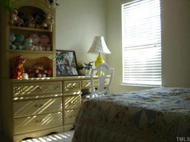 8237 Martello Lane Raleigh, NC 27613 - Photo 4 of 10 a bed sitting in a bedroom next to a window