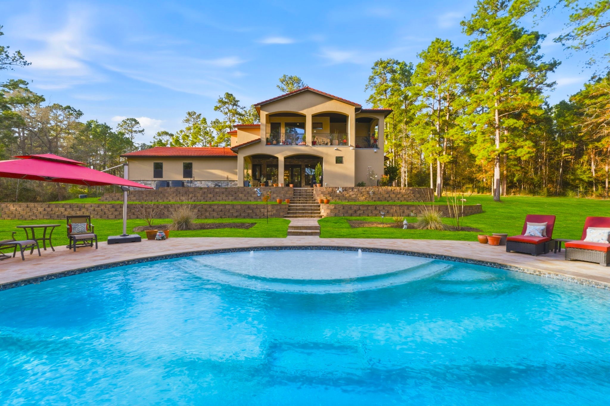 280 Sundog Road Huntsville, TX 77340 - Photo 41 of 50 Beautiful view of the rear elevation showcasing the balconies, covered patio, and steps leading down to the stunning pool.