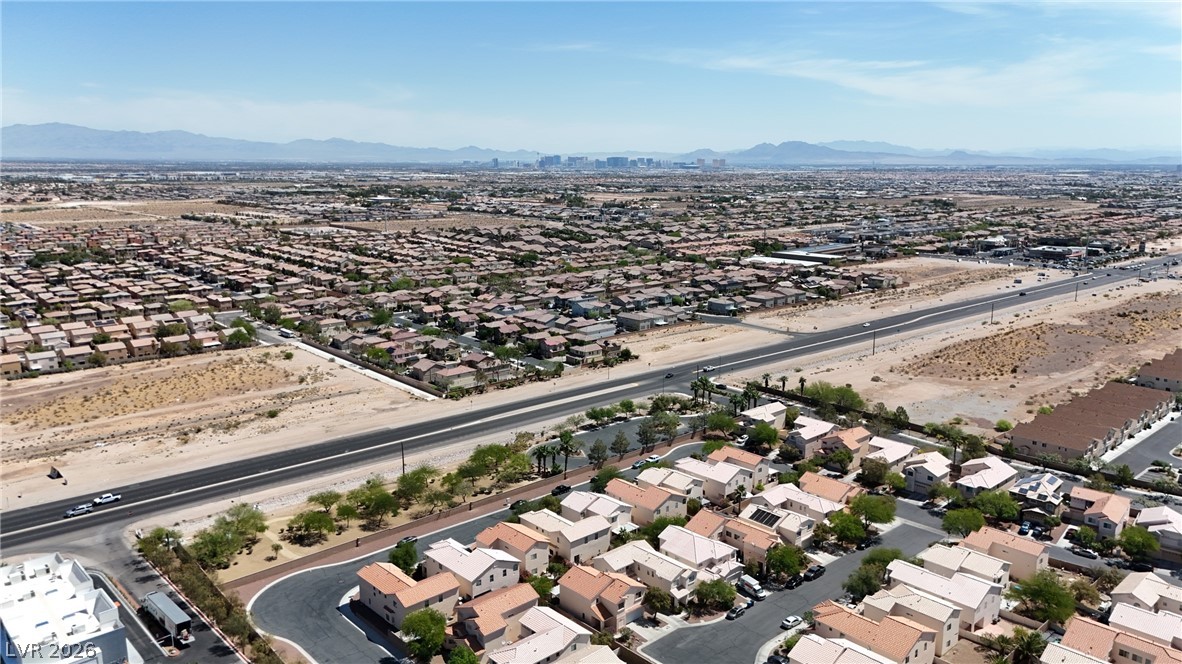 8934 Deep Ridge Court Las Vegas, NV 89178 - Photo 40 of 47 An aerial perspective reveals a vast neighborhood nestled amidst the desert landscape, with a distant city skyline.