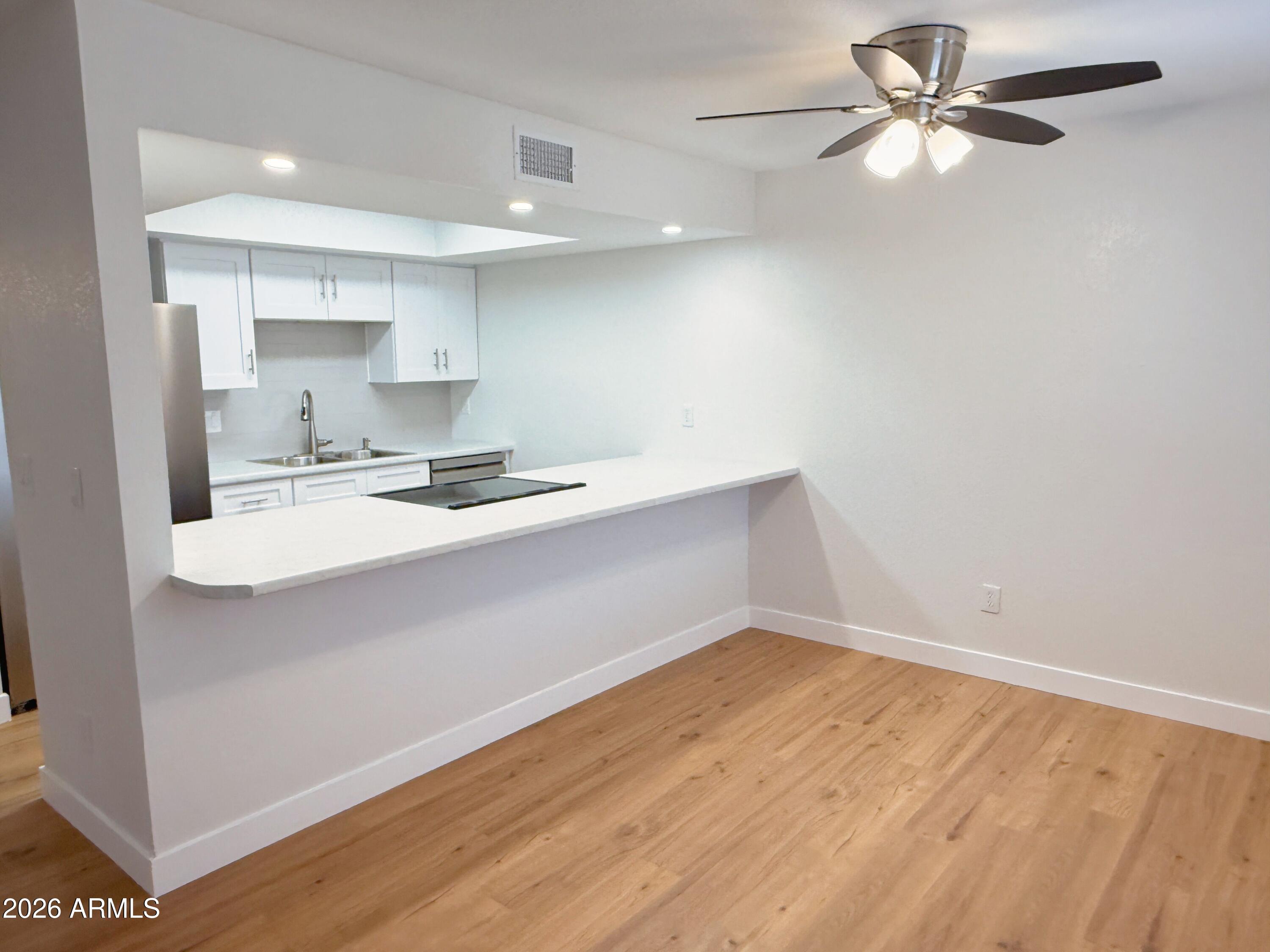 18202 North Cave Creek Road, Unit 148 Phoenix, AZ 85032 - Photo 4 of 19 a kitchen with a sink cabinets and wooden floor