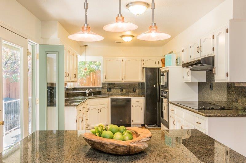 40896 Cherokee Oaks Drive Three Rivers, CA 93271 - Photo 8 of 23 a kitchen with stainless steel appliances kitchen island granite countertop a refrigerator a stove and a sink