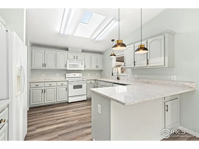 a kitchen with kitchen island granite countertop a sink a stove and cabinets