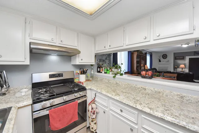 a kitchen with stainless steel appliances granite countertop a stove and cabinets