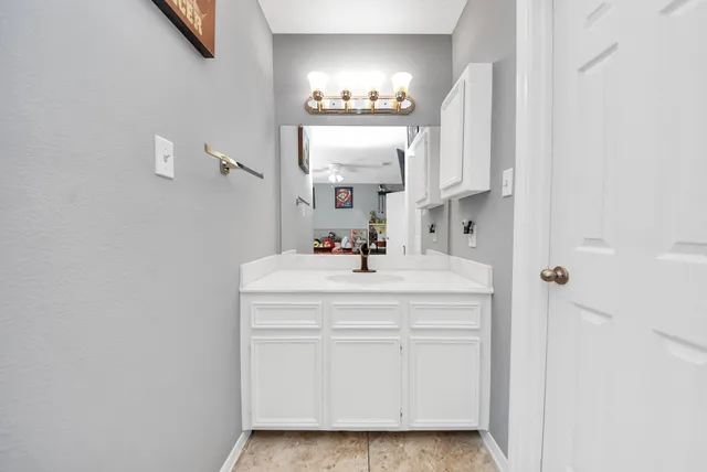 a bathroom with a sink vanity and a mirror
