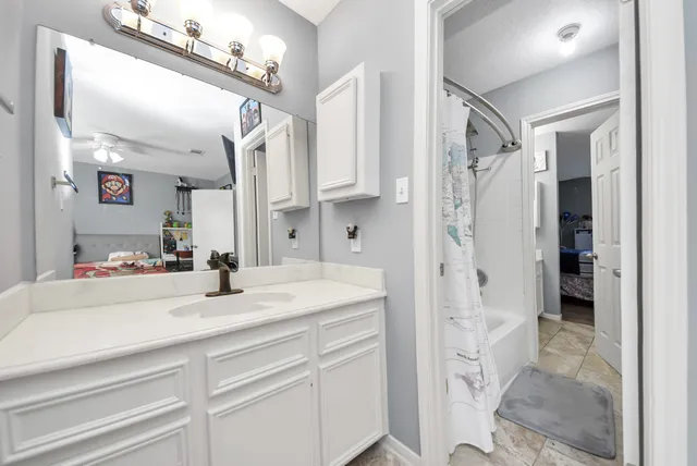 a bathroom with a sink vanity granite shower and a mirror
