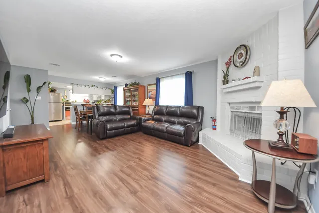 a living room with fireplace furniture and a wooden floor