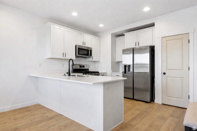 3473 Hardman Way Lehi, UT 84048 - Photo 5 of 22 Kitchen with stainless steel appliances, a peninsula, white cabinetry, light wood finished floors, and recessed lighting