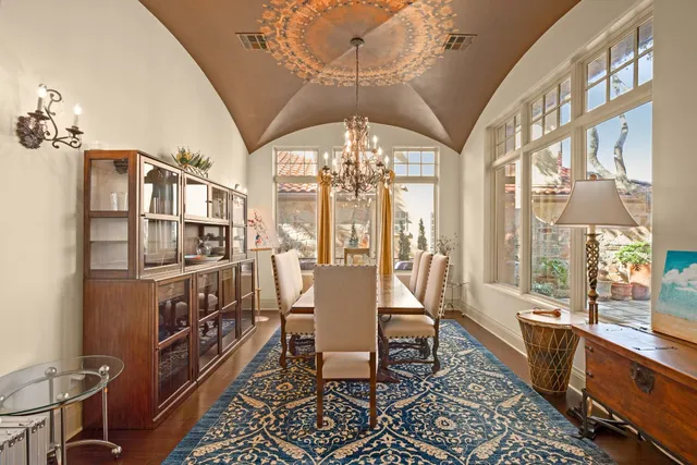 a dining room with furniture a chandelier and wooden floor