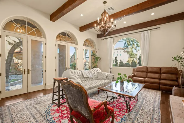 a living room with furniture a chandelier and a dining table