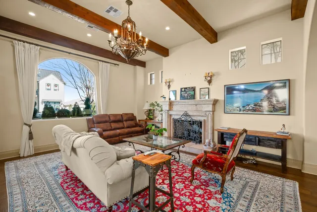 a living room with furniture a chandelier and a fireplace