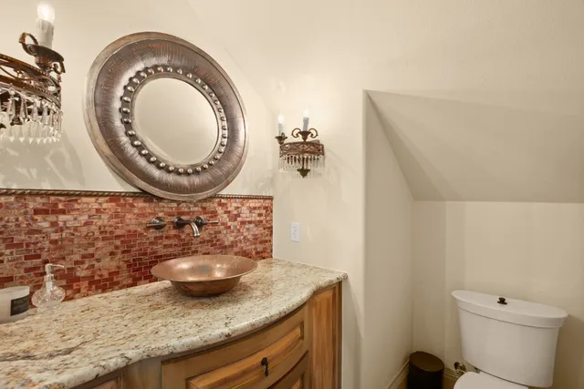 a bathroom with a granite countertop sink and a mirror