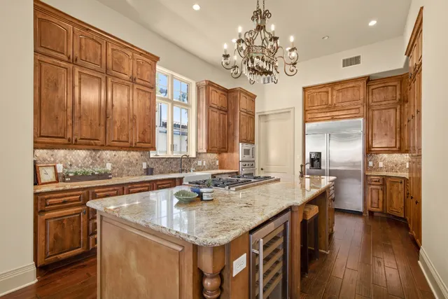 a kitchen with stainless steel appliances granite countertop a sink refrigerator and cabinets