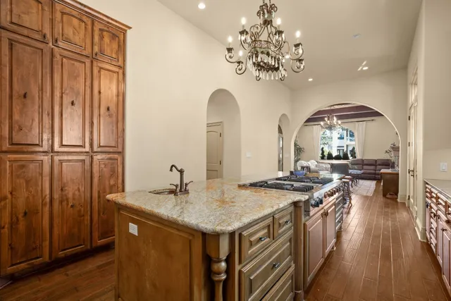 a view of a kitchen with a sink and dishwasher with wooden floor