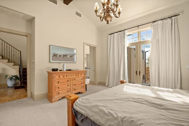 a bedroom with a bed and a chandelier